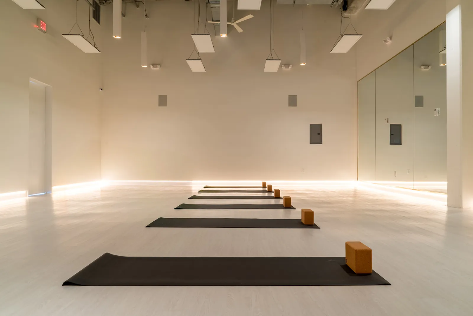 Inside the SOL Yoga Fort Lauderdale studio, mats and blocks laid out on the floor of the bright practice room